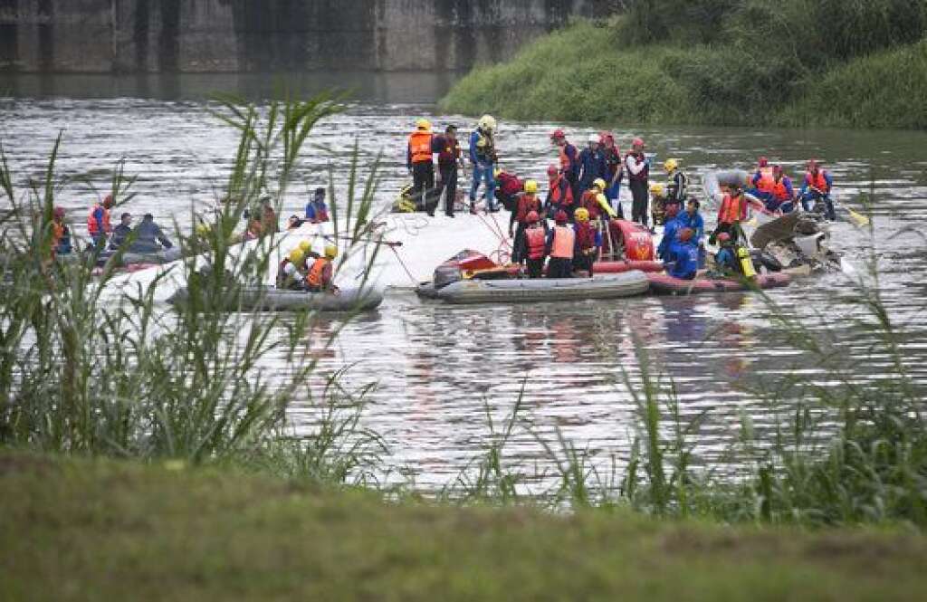 TAIPEI, TAIWAN - FEBRUARY 04:  Rescue teams work to free people from a TransAsia Airways ATR 72-600 turboprop airplane that crashed into the Keelung River shortly after takeoff from Taipei Songshan airport on February 4, 2015 in Taipei, Taiwan. Over 50 people were onboard the aircraft when it clipped a bridge and crashed into the river. Twelve deaths have currently been reported.  (Photo by Ashley Pon/Getty Images)
