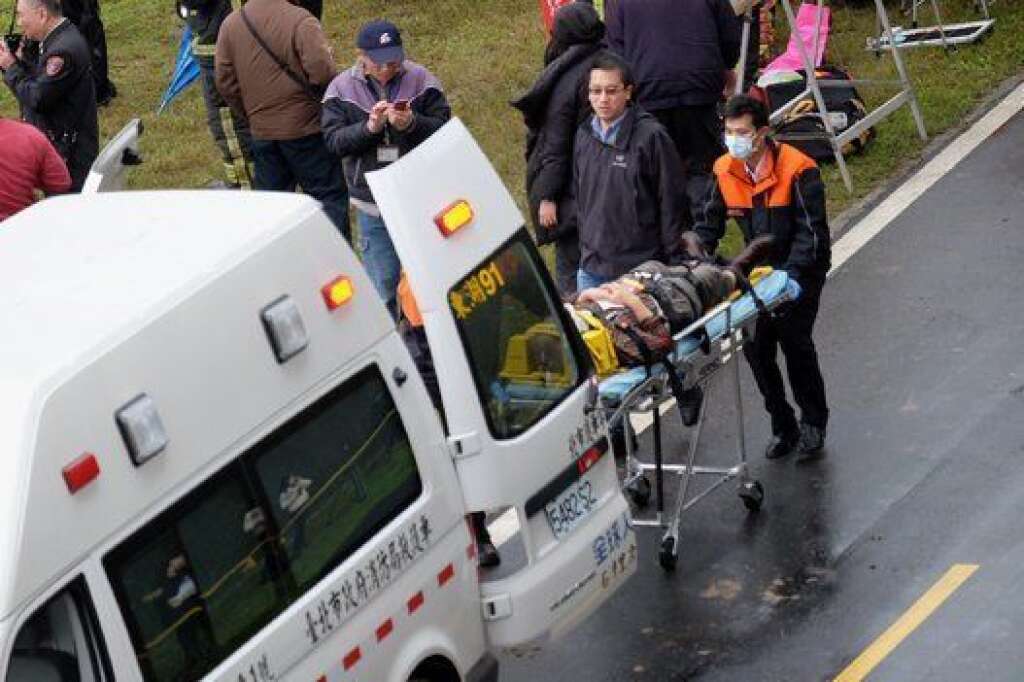 Rescue personnel put an injured passenger from a TransAsia ATR 72-600 turboprop plane that crash-landed into a river outside Taiwan's capital Taipei into an ambulance in New Taipei City on February 4, 2015. The passenger plane with 58 people on board was on a domestic flight when it plunged into the river, with at least 10 people rescued and dozens trapped inside, according to television reports.   AFP PHOTO / SAM YEH        (Photo credit should read SAM YEH/AFP/Getty Images)