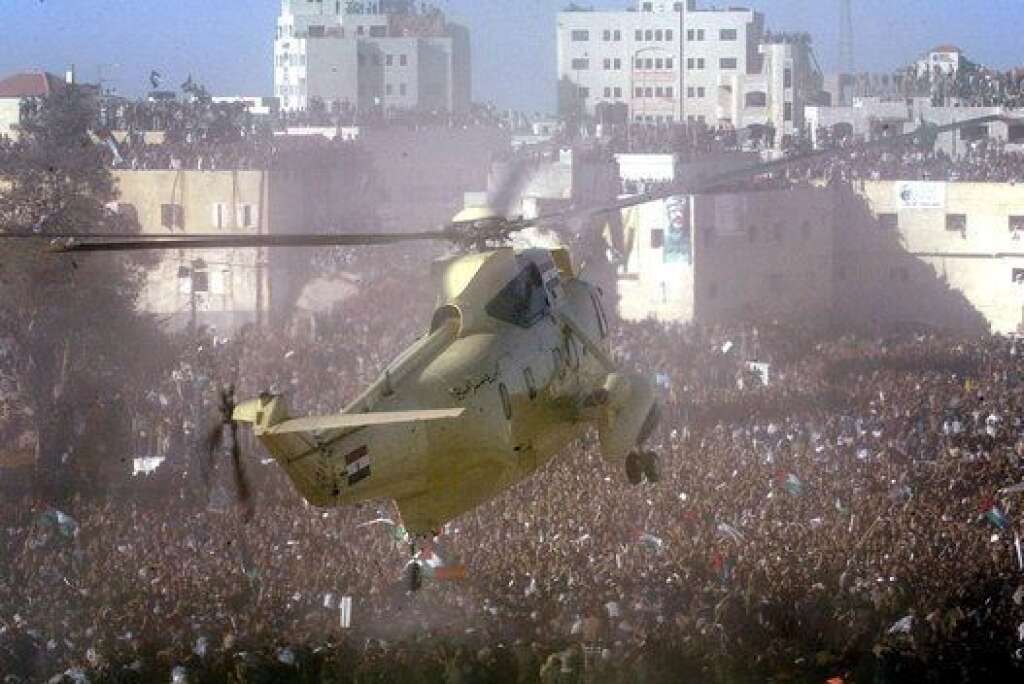 Les funérailles de Yasser Arafat - Le cercueil de Yasser Arafat arrive à bord d’un hélicoptère à la Mouqataa. Sitôt que appareil se pose, des milliers de Palestiniens bousculent sans difficulté le service d’ordre, puis entourent l’hélicoptère, provoquant une cohue indescriptible et empêchant l’ouverture de la porte de l’appareil.