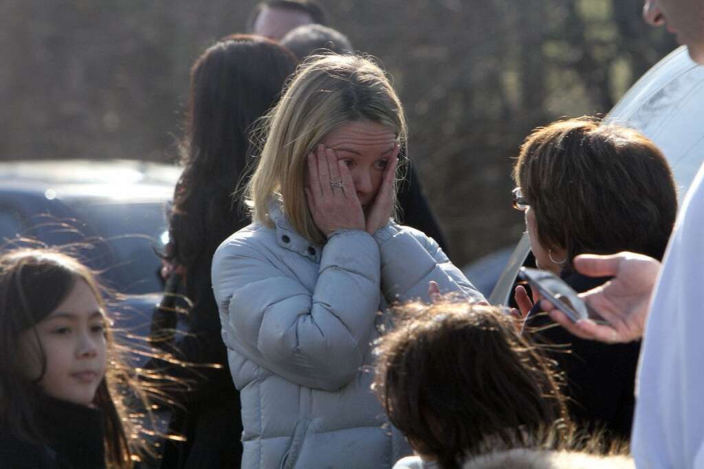 Sandy Hook School Shooting Newtown - A woman weeps as she arrives to pick up her children at the Sandy Hook Elementary School, Friday, Dec. 14, 2012 in Newtown, Conn. A man opened fire inside the Connecticut elementary school Friday, killing 26 people, including 20 children, and forcing students to cower in classrooms and then flee with the help of teachers and police. (AP Photo/The Journal News, Frank Becerra Jr.)
