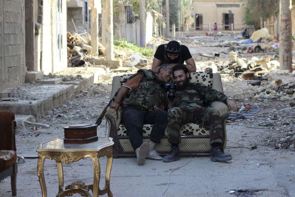 - Les rebelles s'amusent des photos prise par un reporter, à Deir al-Zor, le 14 juin 2013.