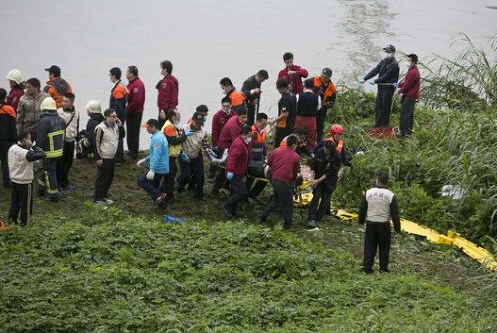TAIPEI, TAIWAN - FEBRUARY 04:  A rescue crew carries a passenger from a TransAsia Airways ATR 72-600 turboprop airplane that crashed into the Keelung River shortly after takeoff from Taipei Songshan airport on February 4, 2015 in Taipei, Taiwan.  Over 50 people were onboard the aircraft when it clipped a bridge and crashed into the river. At least two deaths have been reported. (Photo by Ashley Pon/Getty Images)