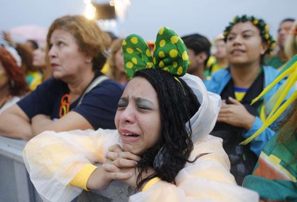 Brazil Soccer WCup - A Brazil soccer fan reacts in frustration as she watches her team play a World Cup semifinal match against Germany on a live telecast inside the FIFA Fan Fest area on Copacabana beach in Rio de Janeiro, Brazil, Tuesday, July 8, 2014. (AP Photo/Leo Correa)