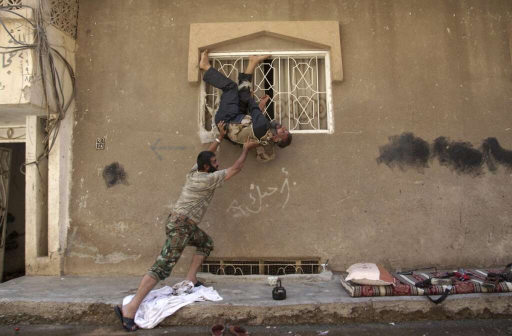- Un rebelle fait semblant de tomber et s'amuse avec un autre combattant. A Deir al-Zor, le 7 juillet 2013.