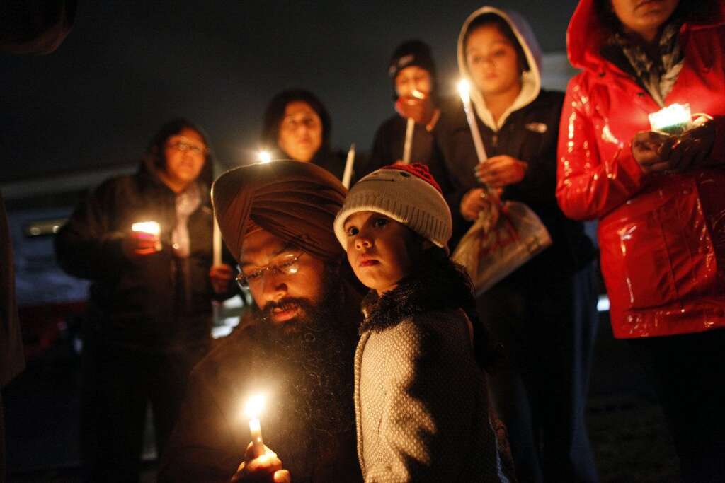 Sandy Hook Elementary School Shooting - Eknoor Kaur, 3, stands with her father Guramril Singh during a candlelight vigil outside Newtown High School before an interfaith vigil with President Barack Obama, Sunday, Dec. 16, 2012, in Newtown, Conn. A gunman walked into Sandy Hook Elementary School in Newtown Friday and opened fire, killing 26 people, including 20 children. (AP Photo/Jason DeCrow)