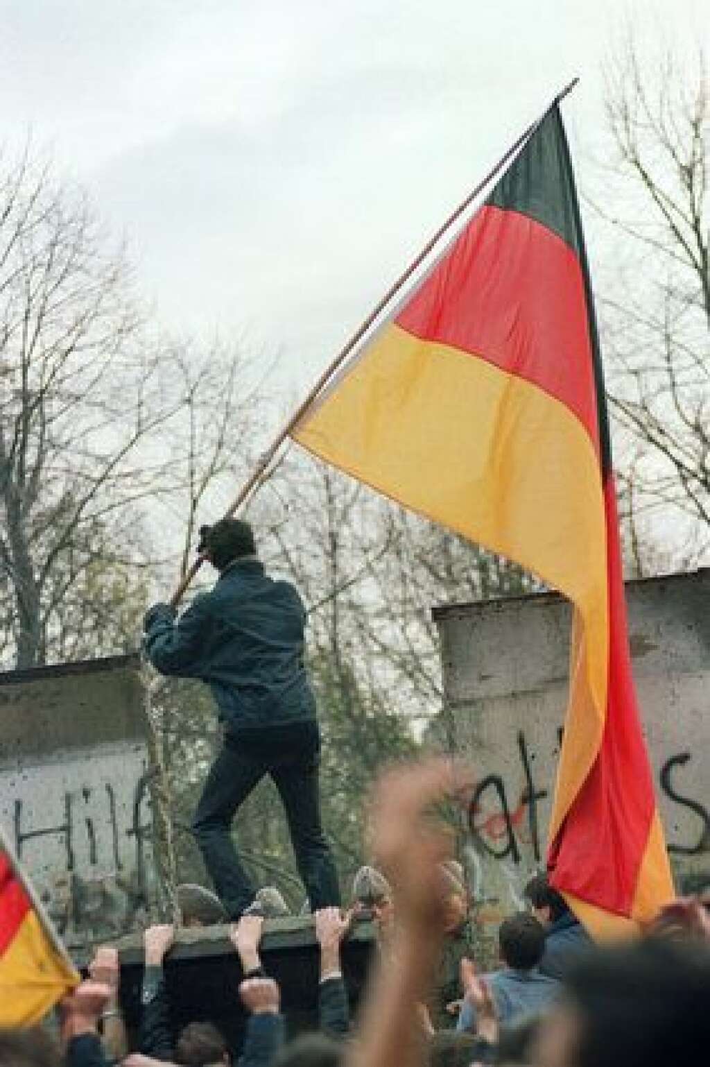11 novembre 1989 - Un Allemand de l'Ouest s'apprête à planter symboliquement le drapeau de la RFA de l'autre côté du mur.