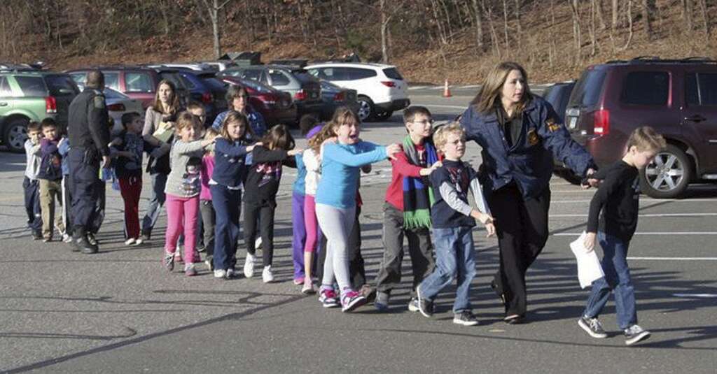 Sandy Hook Elementary School Shooting - In this photo provided by the Newtown Bee, Connecticut State Police lead children from the Sandy Hook Elementary School in Newtown, Conn., following a reported shooting there Friday, Dec. 14, 2012.