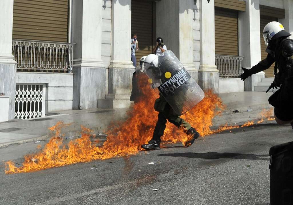 - Riot police try to avoid petrol bombs thrown by protesters during a 24-hour nationwide general strike, Athens, Thursday, Oct. 18, 2012. Hundreds of youths pelted riot police with petrol bombs, bottles and chunks of marble Thursday as yet another Greek anti-austerity demonstration descended into violence. (AP Photo/Nikolas Giakoumidis)