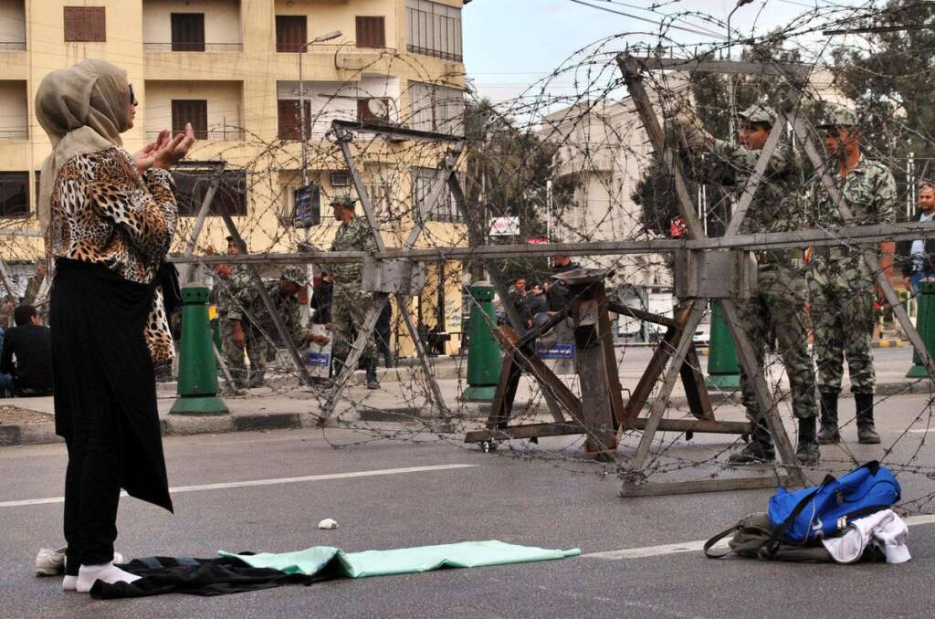 Une femme prie un soldat - Alors que les soldats du palais présidentiel l'entourent de barbelés, une femme prie.