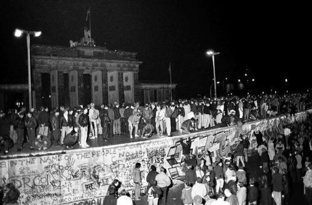 9 novembre 1989 - Pour célébrer l'annonce de l'ouverture de la frontière entre l'Allemagne de l'Est (RDA) et de l'Ouest (RFA), des Berlinois des deux côtés escaladent le mur.