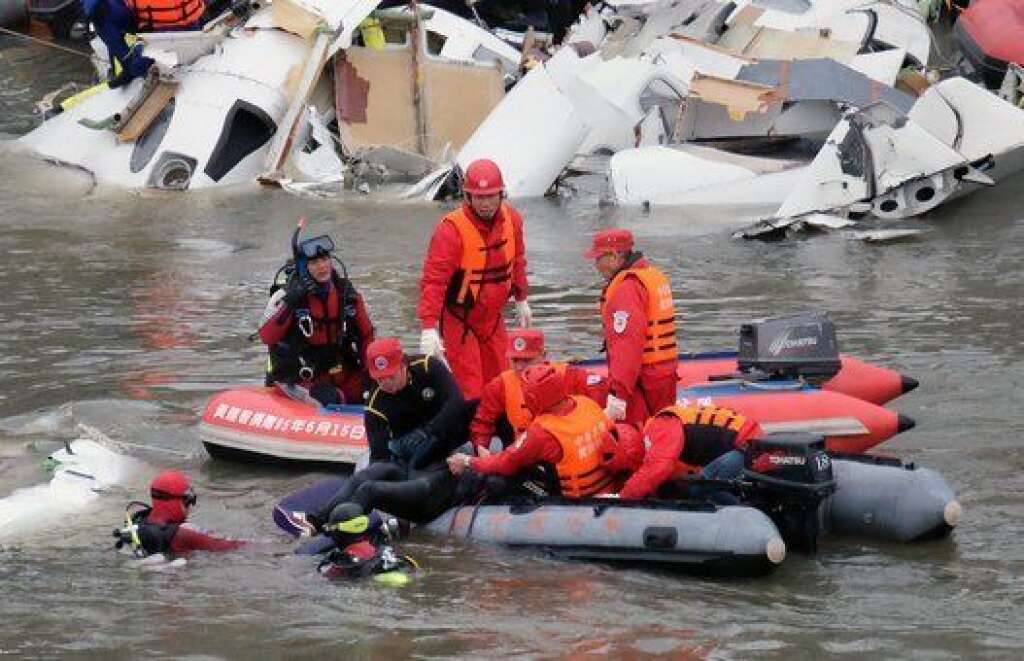 Rescue personnel in a rubber dinghy lift a passenger (bottom C) from the waters around the wreckage of a TransAsia ATR 72-600 turboprop plane that crash-landed into the Keelung river outside Taiwan's capital Taipei in New Taipei City on February 4, 2015. At least 16 people were killed when TransAsia Aiways Flight GE235 with 58 people on board clipped a road bridge and plunged into the river in Taiwan, in the airline's second crash in just seven months.    AFP PHOTO / SAM YEH        (Photo credit should read SAM YEH/AFP/Getty Images)