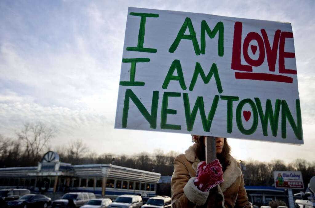 - A Newtown, Conn., resident, who declined to give her name, sits at an intersection holding a sign for passing motorists up the road from the Sandy Hook Elementary School, Saturday, Dec. 15, 2012, in Newtown, Conn. The massacre of 26 children and adults at Sandy Hook Elementary school elicited horror and soul-searching around the world even as it raised more basic questions about why the gunman, 20-year-old Adam Lanza, would have been driven to such a crime and how he chose his victims. (AP Photo/David Goldman)