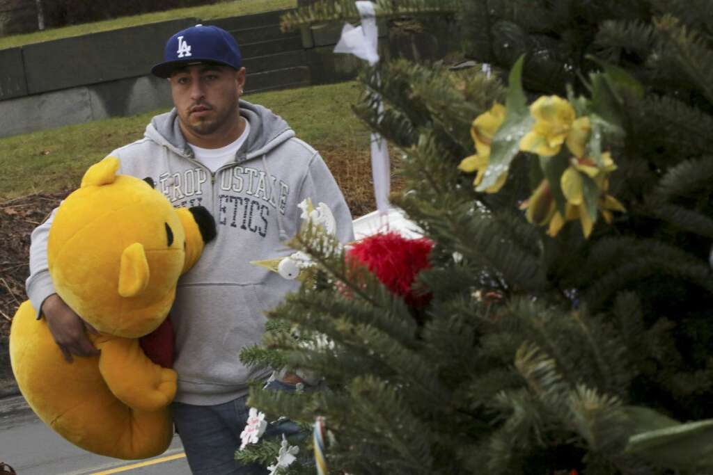 - A mourner carries a giant Winnie the Pooh stuffed animal to place at one of the makeshift memorials for the Sandy Hook Elementary School shooting victims, Monday,Dec. 17, 2012 in Newtown, Conn. Authorities say gunman Adam Lanza killed his mother at their home on Friday and then opened fire inside the Sandy Hook Elementary School in Newtown, killing 26 people, including 20 children, before taking his own life. (AP Photo/Mary Altaffer)