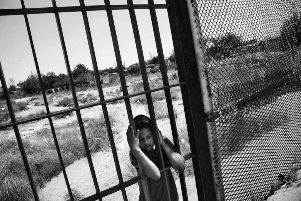 Un enfant du côté mexicain de la clôture à Colonia Rancho Anapra, un quartier voisin de Ciudad Juárez. États-Unis/Mexique, 2011 -