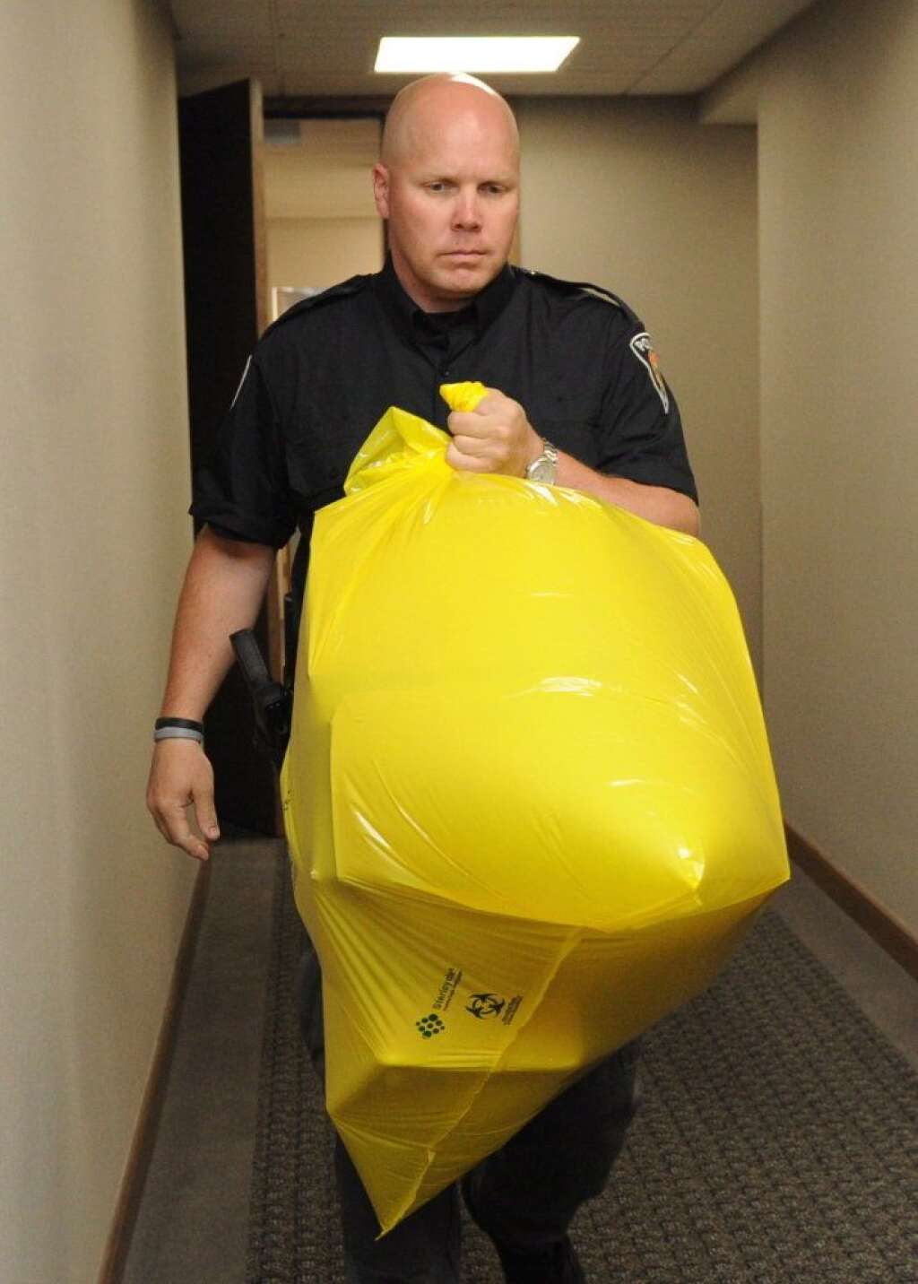 - Un policier de la GRC transporte dans un sac le colis livré aux bureaux du Parti conservateur, à Ottawa, qui contenait un pied. (PC/Sean Kilpatrick)