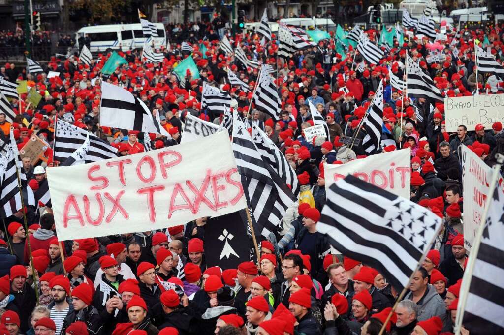 28 octobre 2013: les bonnets rouges en Bretagne - Mouvement hétéroclite rassemblant identitaires bretons, agriculteurs, distributeurs, et syndicalistes, les bonnets rouges émergent à l'occasion d'une manifestation contre l'écotaxe dans le Finistère. Il rassemble des dizaines de milliers de personnes en novembre "pour l'emploi et la Bretagne". Pour couper court à ce nouveau symptôme du ras-le-bol fiscal, le gouvernement annonce un "pacte d'avenir" pour aider la région et le report de l'application de l'écotaxe.    <strong>A RELIRE:</strong> <a href="https://www.google.com/url?q=http://www.huffingtonpost.fr/joel-cornette/les-bonnets-rouges-en-1675_b_4259605.html&sa=U&ei=n8ylUtX7NMer7Aa-rIE4&ved=0CAYQFjAA&client=internal-uds-cse&usg=AFQjCNEVWzrc0MNtZJkd-gJiGeJiIj4HpQ" target="_hplink">En 1675, c'était déjà le "ras-le-bol fiscal"</a>