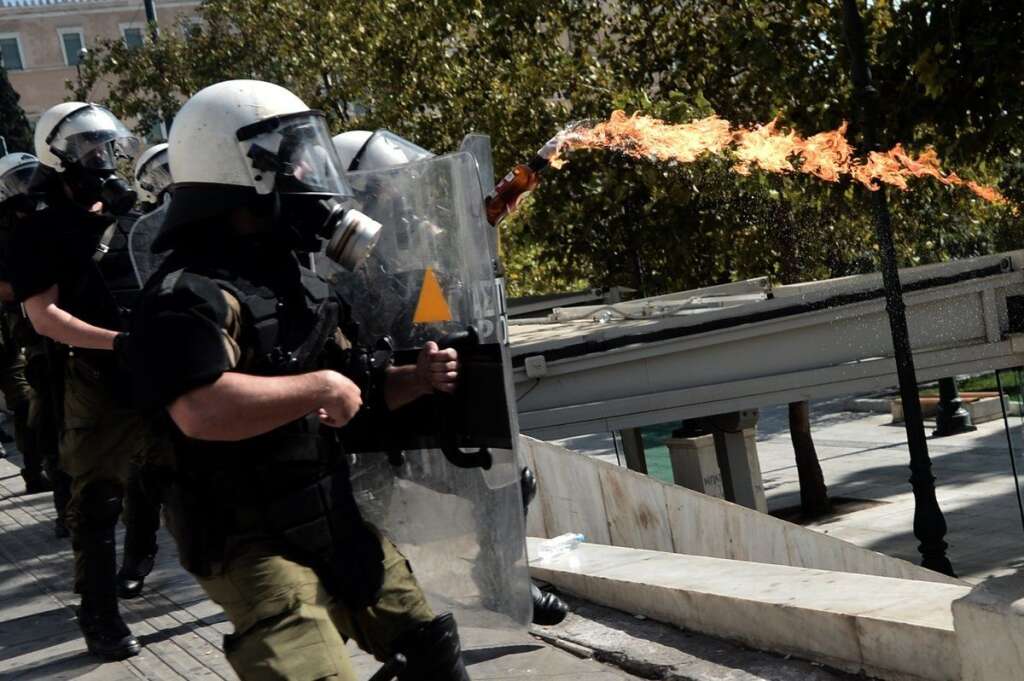 GREECE-FINANCE-PUBLIC-DEBT-EU-DEMO - Riot police receives a firebomb sent by demonstrators during a 24-hour strike in Athens on October 18, 2012. Greek riot police fired tear gas to disperse protesters at an anti-austerity rally in Athens held during a national general strike as EU leaders were to tackle the eurozone crisis at a summit. The protesters had broken through a police line outside luxury hotels on central Syntagma Square and scattered groups of youths later attacked police with stones and firebombs, an AFP reporter said.  AFP PHOTO / ARIS MESSINIS        (Photo credit should read ARIS MESSINIS/AFP/Getty Images)