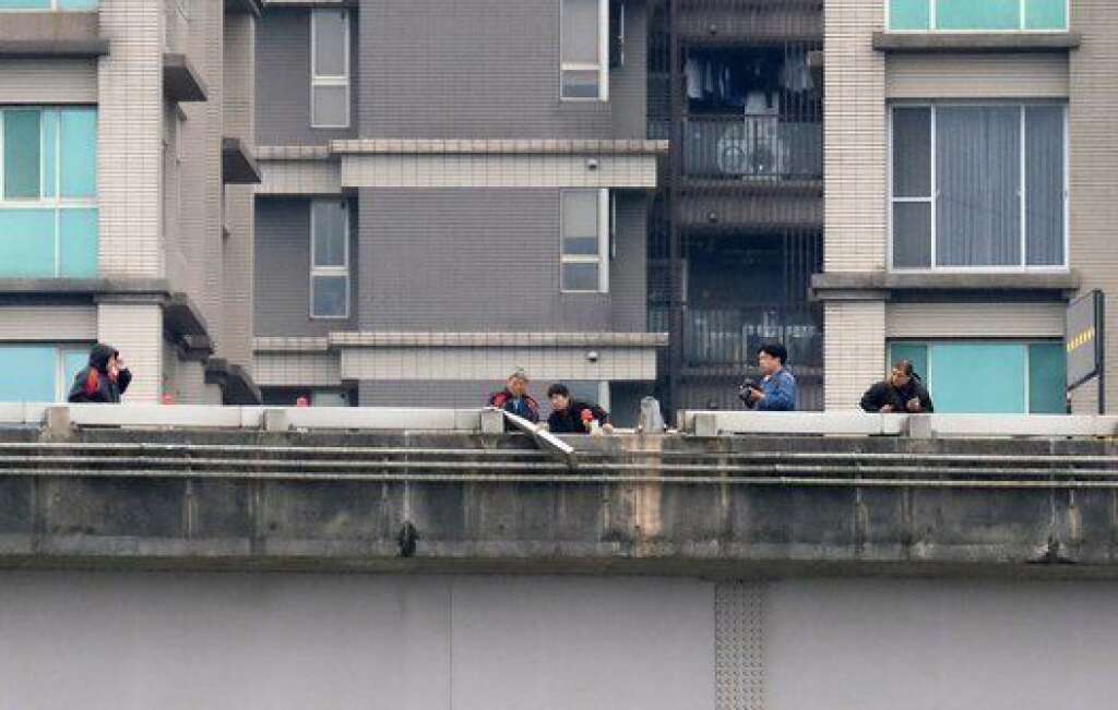 Police check a bridge which was damaged when a TransAsia ATR 72-600 turboprop plane clipped it and crashed into the Keelung river outside Taiwan's capital Taipei in New Taipei City on February 4, 2015. At least 16 people were killed when TransAsia Aiways Flight GE235 with 58 people on board clipped the road bridge and plunged into the river in Taiwan, in the airline's second crash in just seven months.   AFP PHOTO / SAM YEH        (Photo credit should read SAM YEH/AFP/Getty Images)
