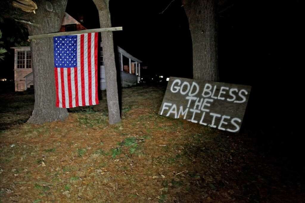 Sandy Hook Elementary School Shooting - Across the street from the elementary school in Sandy Hook, Conn. neighbors hoisted an American flag and created a make-shift prayer for the deceased inside the school late Friday Dec. 14, 2012. (AP Photo/Robert Ray)