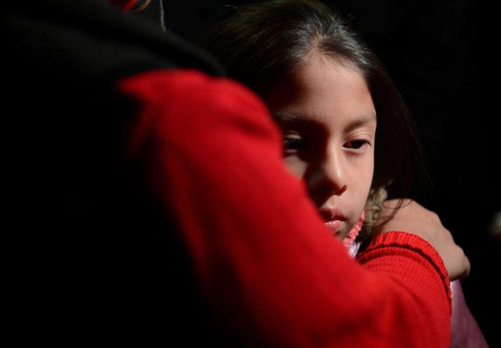 Sandy Hook Elementary School Shooting - Cynthia Alvarez (R) is comforted by her mother Lilia as people gather for a prayer vigil at St Rose Church following an elementary school shooting in Newtown, Connecticut, December 14, 2012.  A young gunman slaughtered 20 small children and six teachers on Friday after walking into a school in an idyllic Connecticut town wielding at least two sophisticated firearms AFP PHOTO/Emmanuel DUNAND