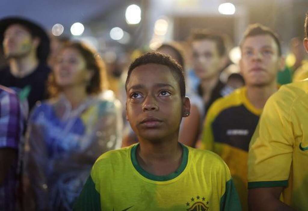Brazil Soccer WCup - A Brazil soccer fan cries as he watches his team get beat during a live telecast of the semi-finals World Cup soccer match between Brazil and Germany, inside the FIFA Fan Fest area on Copacabana beach in Rio de Janeiro, Brazil, Tuesday, July 08, 2014. (AP Photo/Leo Correa)