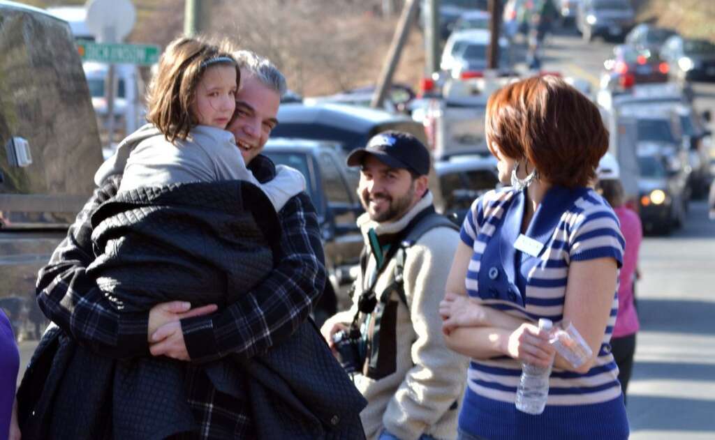- A young girl is comforted following a shooting at the Sandy Hook Elementary School in Newtown, Conn., about 60 miles (96 kilometers) northeast of New York City, Friday, Dec. 14, 2012. A gunman entered the school Friday morning and killed at least 26 people, including 20 young children. (AP Photo/The New Haven Register, Melanie Stengel)