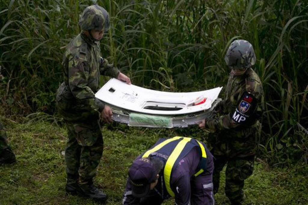 TAIPEI, TAIWAN - FEBRUARY 04:  Rescue team carrry a window from a TransAsia Airways ATR 72-600 turboprop airplane that crashed into the Keelung River shortly after takeoff from Taipei Songshan airport on February 4, 2015 in Taipei, Taiwan. Over 50 people were onboard the aircraft when it clipped a bridge and crashed into the river. Twelve deaths have currently been reported.  (Photo by Ashley Pon/Getty Images)