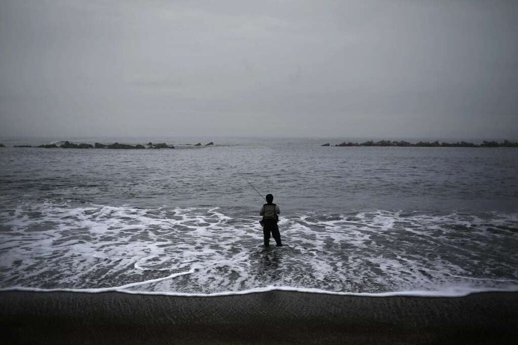 - Un homme pêche sur une plage municipale fermée au public.