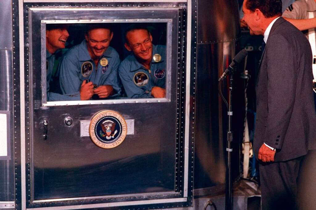 Neil Armstrong, le 24 juillet 1969 - Une fois de retour sur la planète bleue, le président américain Richard Nixon est venu féliciter l'équipe, alors que celle-ci est encore dans le caisson de quarantaine.