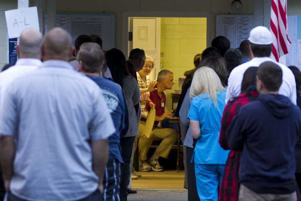 U.S. Citizens Head To The Polls To Vote In Presidential Election - CRAWFORDVILLE, FL -  NOVEMBER 6:  A poll worker holds up the line just after dawn as voters queue to place their ballots at the tiny County Polling House in the Ivan Community of Wakulla County on November 6, 2012 in Crawfordville, Florida. The swing state of Florida is recognised to be a hotly contested battleground that offers 29 electoral votes, as recent polls predict that the race between U.S. President Barack Obama and Republican presidential candidate Mitt Romney remains tight.  (Photo by Mark Wallheiser/Getty Images)
