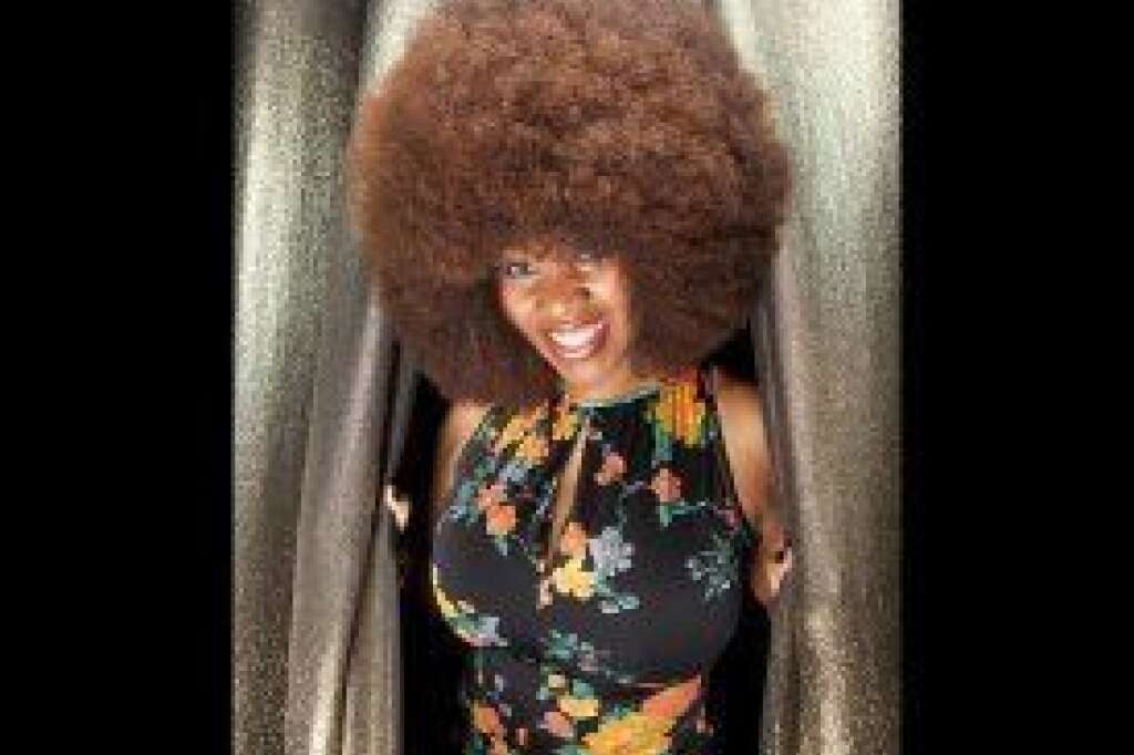 Aevin Dugas - Largest Afro - Aevin Dugas of New Orleans, La., is the proud owner of a record-breaking afro. It has a circumference of 4 feet, 4 inches. She trims her afro two or three times a year, and uses up to five conditioners at once when she washes it.