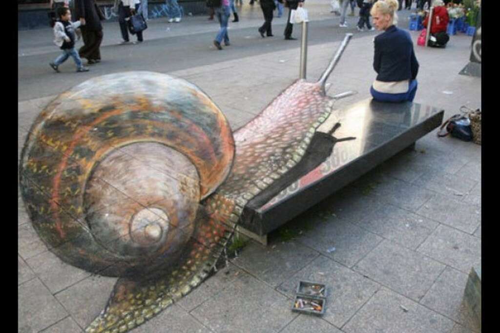 - At first glance, street artist <a href="http://www.huffingtonpost.com/2012/07/12/street-artist-julian-beev_n_1668616.html" target="_hplink">Julian Beever's</a> sidewalk creations look like unfinished chalk drawings of oddly morphed animals or landscapes. But if you happen upon the one perfect angle, the image magically snaps into shape, showing you a giant charging snail or an aerial view of Times Square.     The process is called anamorphosis, which involves drawing a distorted image which gives the impression of a three-dimensional scene from a certain vantage point. According to <em>NPR</em>, the talented artist sets up a camera or a viewfinder in the specific spot he intends his viewers to stand and draws his killer whales and beachy snapshots from that perspective. So if a passerby views the work from that same perspective, the drawings jump to life in their three-dimensional glory. But if they stand from any other position, the chalk creation appears to be elongated fragments of an incomplete design.    Image courtesy Julian Beever