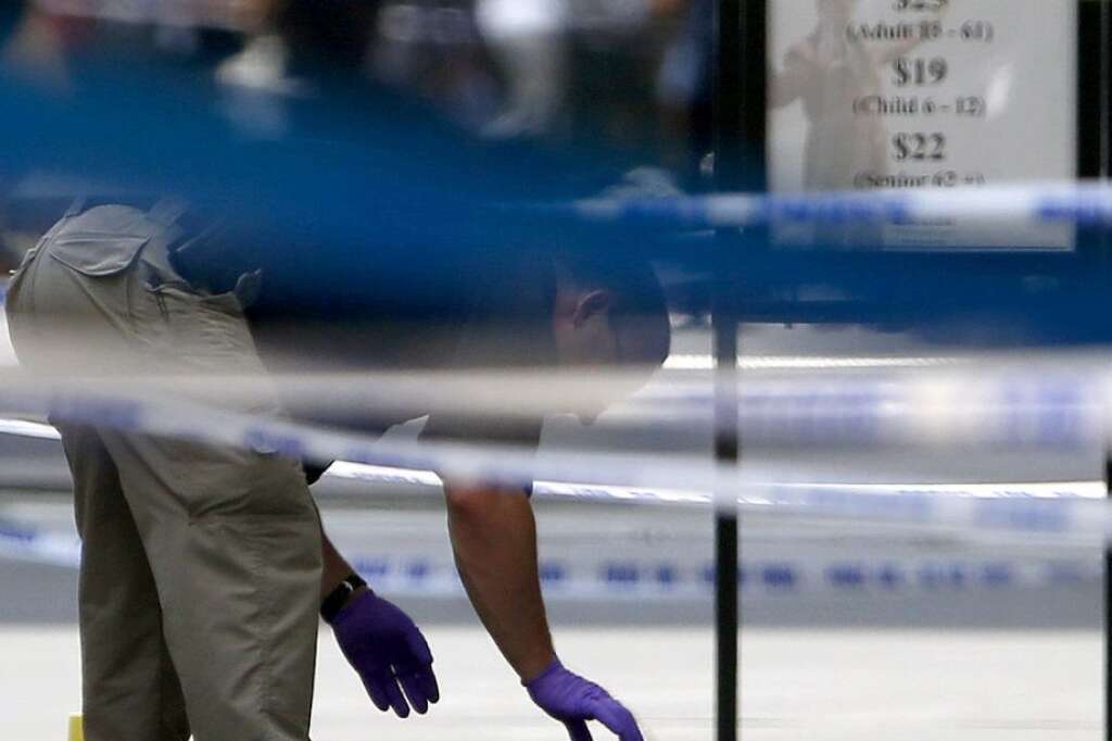 - An official inspects evidence near the Empire State Building in New York following a shooting Friday, Aug. 24, 2012. Police say a recently laid-off worker shot a former colleague to death near the iconic skyscraper, then randomly opened fire on people nearby before firing on police. New York City Mayor Michael Bloomberg said some of the victims may have been hit by police bullets as police and the gunman exchanged fire. (AP Photo/Julio Cortez)