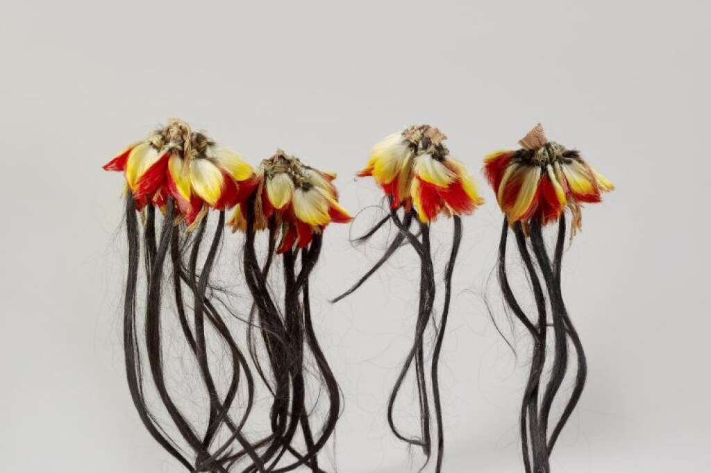 Ornements - Petites plumes de toucan rouges et jaunes et longues mèches de cheveux noirs. Équateur © musée du quai Branly, photo Claude Germain