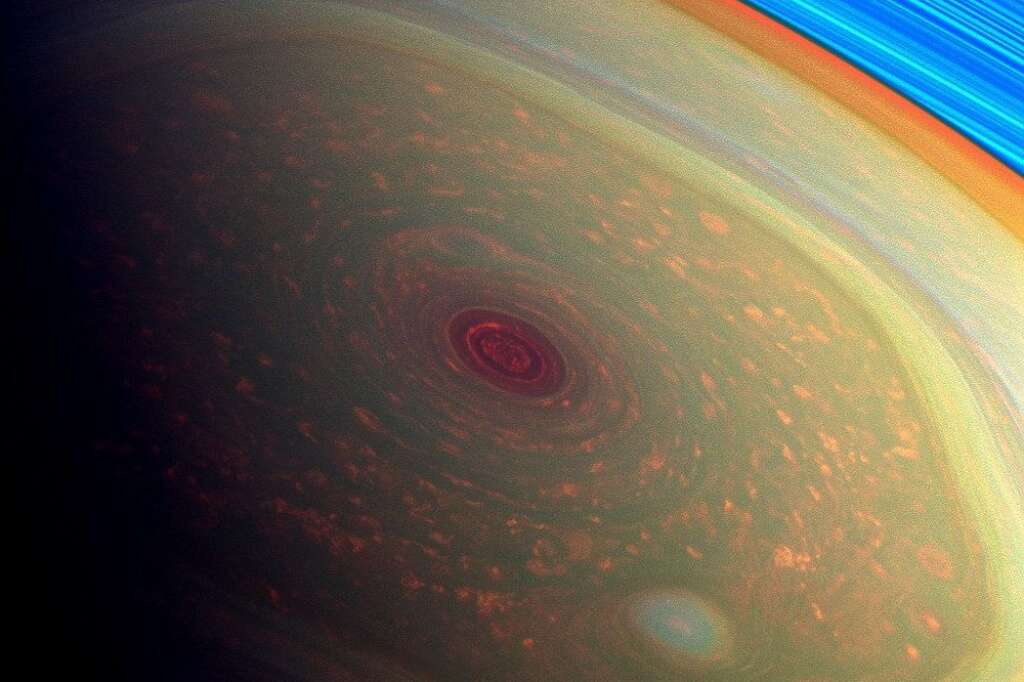 Tempête sur Saturne - Cette image vertigineuse de la mission Cassini, composée de couleurs artificielles, met en lumière les tempêtes de pôle nord de Saturne. Les anneaux de Saturne apparaissent en bleu vif en haut à droite.