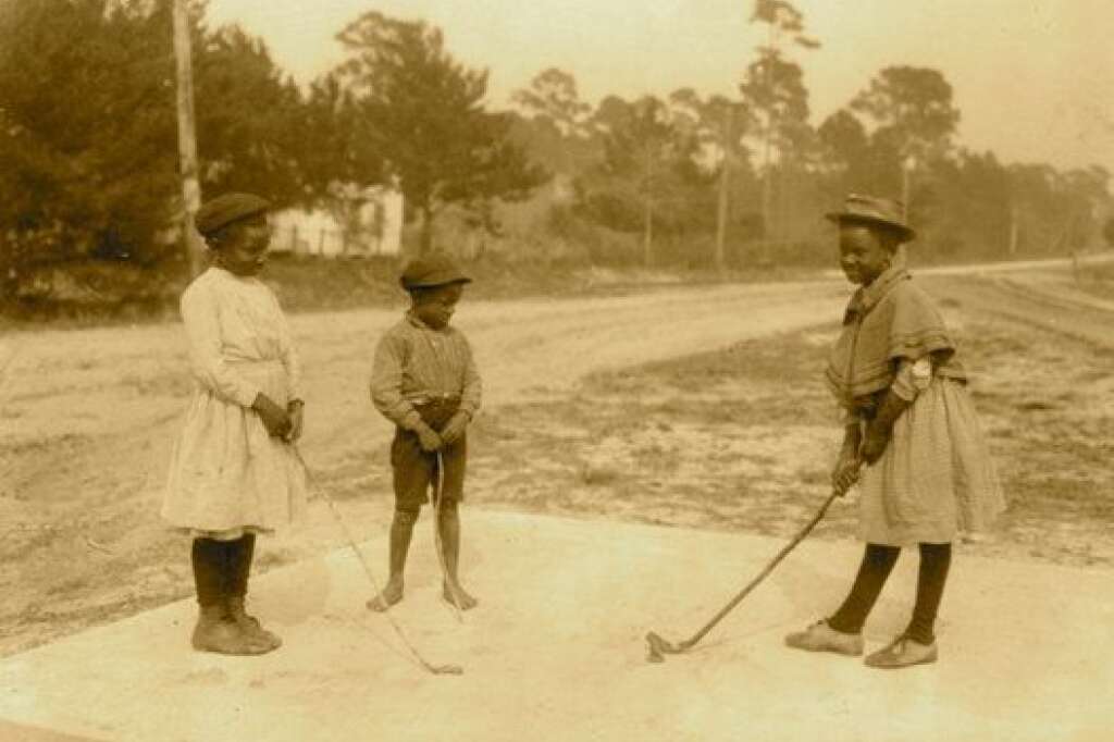 - Environ 1905:  Trois enfants jouant au golf avec des bâtons improvisés.  (Photo pat Buyenlarge/Getty Images)