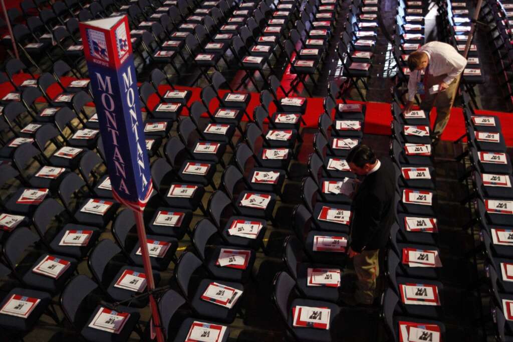 A volunteer places pamphlets on chairs in Montana's delegation seating area before the start of the Republican National Convention in Tampa, Fla., on Tuesday, Aug. 28, 2012. (AP Photo/Lynne Sladky)