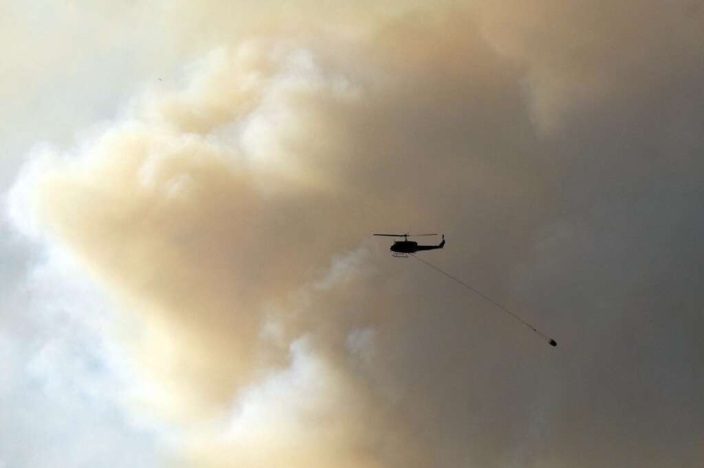 A helicopter battles the Waldo Canyon Fire near Colorado Springs, Colo., on Monday, June 25, 2012. The fire, one of at least a half-dozen wildfires in Colorado as of Monday, has blackened 5.3 square miles and displaced about 6,000 people since it started Saturday. (AP Photo/Bryan Oller)