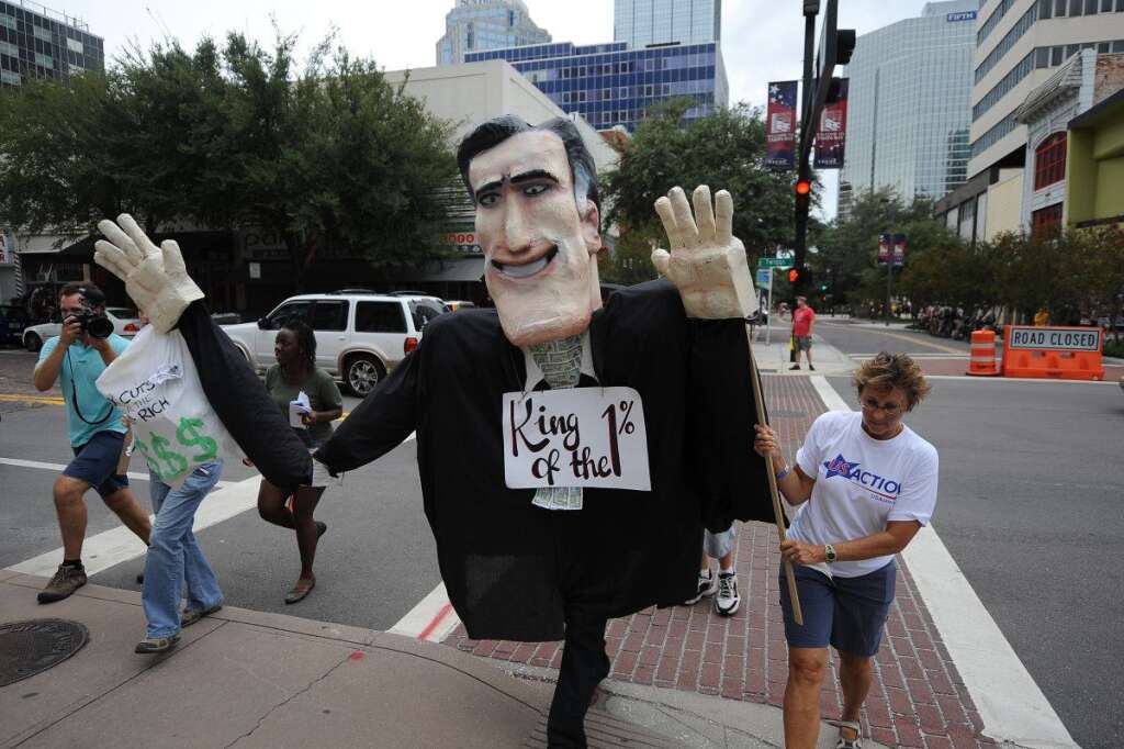US-VOTE-2012-REPUBLICAN CONVENTION - Anti-Mitt Romney protesters march through the streets in Tampa, Florida, on August 26, 2012 ahead of the Republican National Convention. The 2012 Republican National Convention was scheduled to be held at the Tampa Bay Times Forum from August 27-30, 2012,  but was cut short by one day due to incoming severe weather and possible hurricane conditions. AFP PHOTO Robyn BECK        (Photo credit should read ROBYN BECK/AFP/GettyImages)