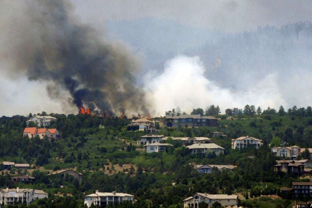 A wildfire burns by Cedar Heights, a gated community near Colorado Springs, Colo., on Sunday, June 24, 2012. The fire erupted and grew out of control to more than 3 square miles early Sunday, prompting the evacuation of more than 11,000 residents and an unknown number of tourists. (AP Photo/The Colorado Springs Gazette, Jerilee Bennett)