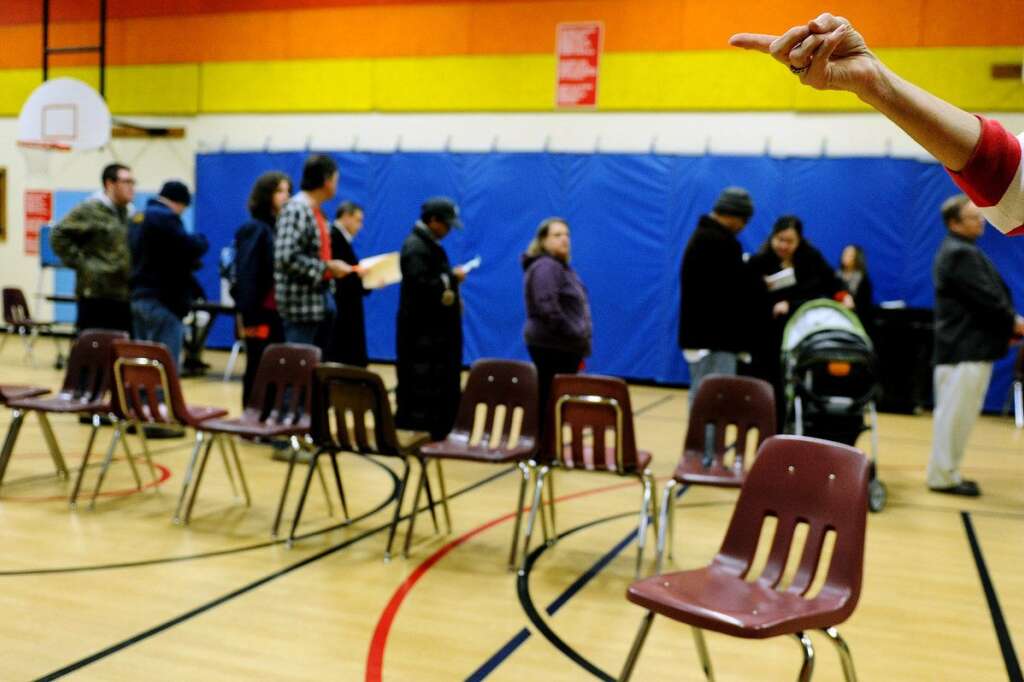 U.S. Citizens Head To The Polls To Vote In Presidential Election - ALEXANDRIA, VA - NOVEMBER 06: People wait inside Washington Mill Elementary School to cast their vote in the U.S. presidential race, on November 6, 2012, in Alexandria, Virginia. Recent polls show that U.S. President Barack Obama and Republican presidential candidate Mitt Romney are in a tight race. (Photo by Patrick Smith/Getty Images)