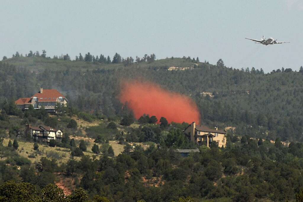 A helicopter drops water on a wildfire near Colorado Springs, Colo., on Sunday, June 24, 2012. The fire erupted and grew out of control to more than 3 square miles early Sunday, prompting the evacuation of more than 11,000 residents and an unknown number of tourists. On Saturday, a blaze destroyed 21 structures near the mountain community of Estes Park. (AP Photo/Bryan Oller)