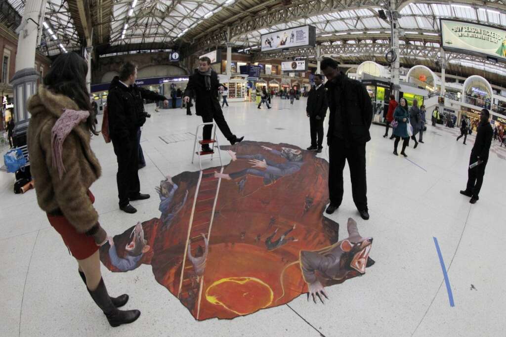 - Commuters step around a 3D art exhibit entitled "Escape the Rat Race" painted on the concourse of Victoria railway station in London to promote a pest control company, Wednesday, Jan. 18, 2012.     (AP Photo/Sang Tan)