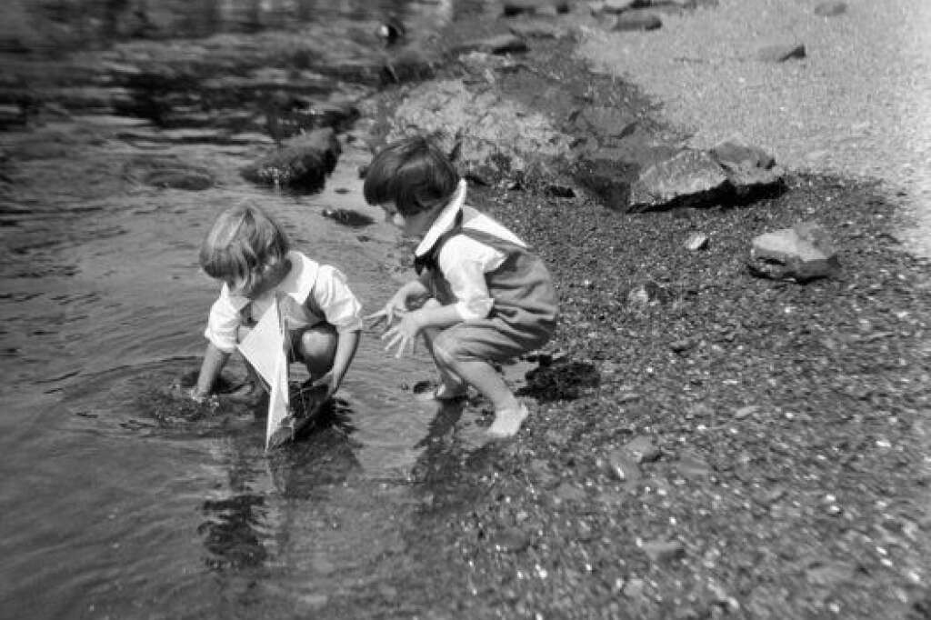 - Environ 1930 : Ces deux enfants s'amusent sur le bord de l'eau avec un bateau jouet. (Photo par H. Armstrong Roberts/Retrofile/Getty Images)