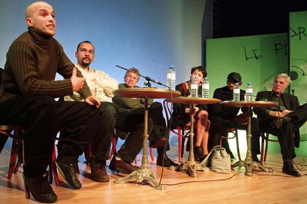 4 mars 2001 - Il renonce également à se présenter aux municipales de Dreux pour laisser toutes ses chances au candidat socialiste. Il reçoit alors le soutien des Verts, de Guy Bedos, de Daniel Cohn-Bendit.  Ici, le chanteur musicien du groupe toulousain "Zebda" Mouss (à gauche), qui présente à Toulouse la liste "Motivé-e-s", prend la parole, le 07 février 2001 à La Haye, lors d'une réunion de soutien à Dieudonné tandis qu'il est encore candidat aux municipales de mars 2001 à Dreux, en présence du député européen Verts Daniel Cohn-Bendit (3eG), de Bahia Idjouadiene (3eD), qui présente la liste "Couleur citoyenne" à Maison Alfort, de Stéphane Pocrain (2eD), porte parole du parti écologiste, et de l'humoriste Guy Bedos (D).