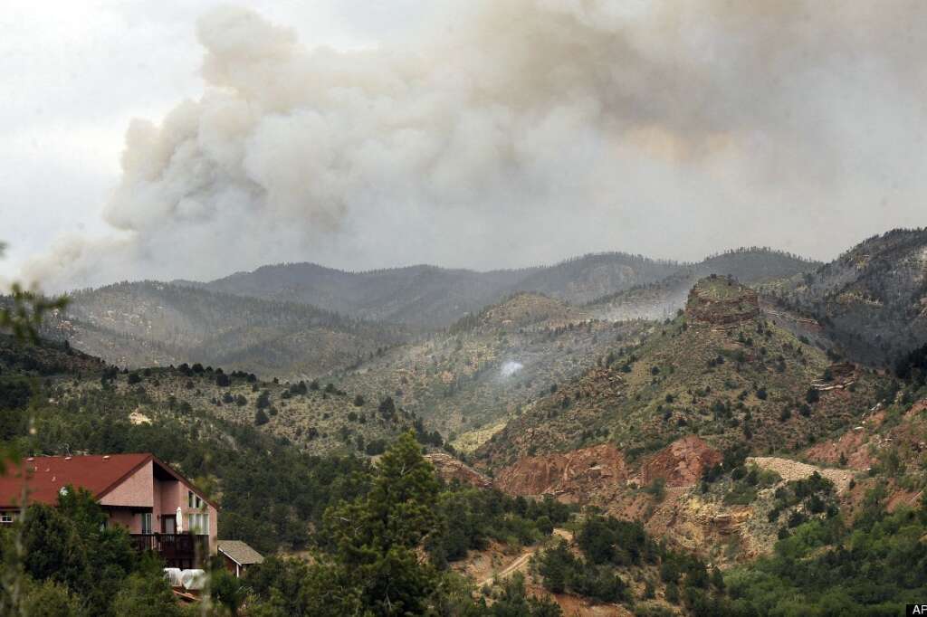 A plume of smoke rises from Ute Pass in the direction of Woodland Park as the Waldo Canyon Fire burns Wednesday, June 27, 2012, in Colorado Springs, Colo. The wildfire doubled in size overnight to about 24 square miles (62 square kilometers), and has so far forced mandatory evacuations for more than 32,000 residents. (AP Photo/The Gazette, Jerilee Bennett)