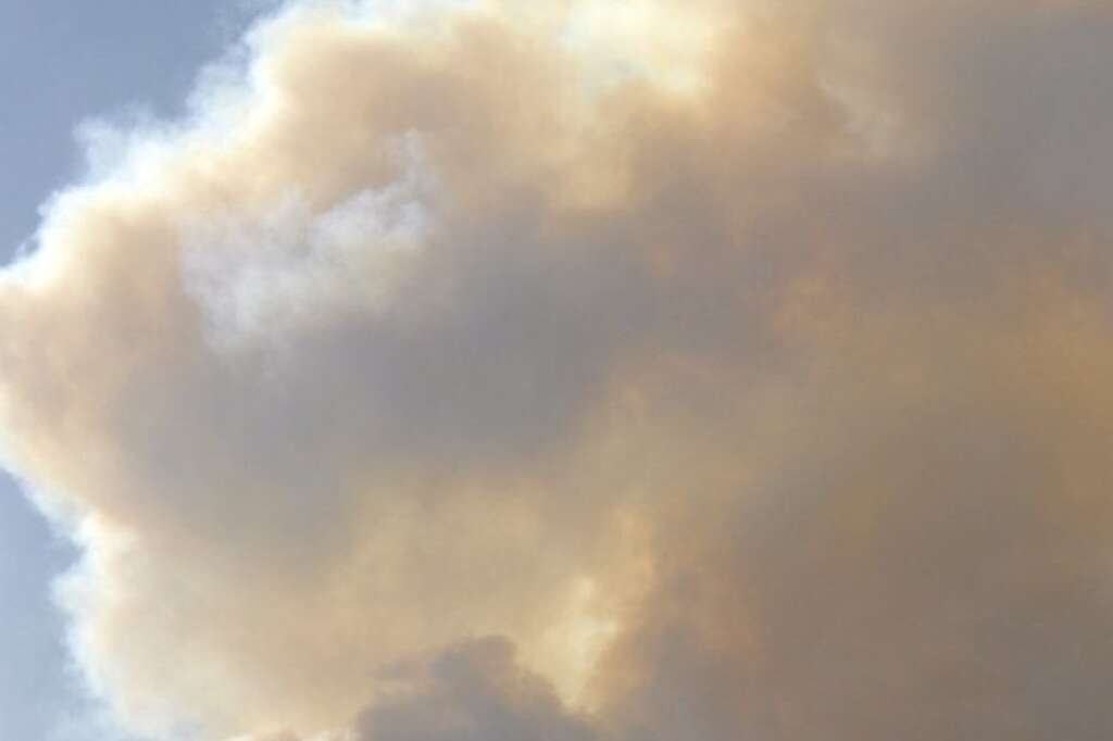 A plane flies through a rising plume of smoke from the Waldo Canyon Fire near Colorado Springs, Colo. on Monday, June 25, 2012. The fire, one of at least a half-dozen wildfires in Colorado as of Monday, has blackened 5.3 square miles and displaced about 6,000 people since it started Saturday. (AP Photo/Bryan Oller)
