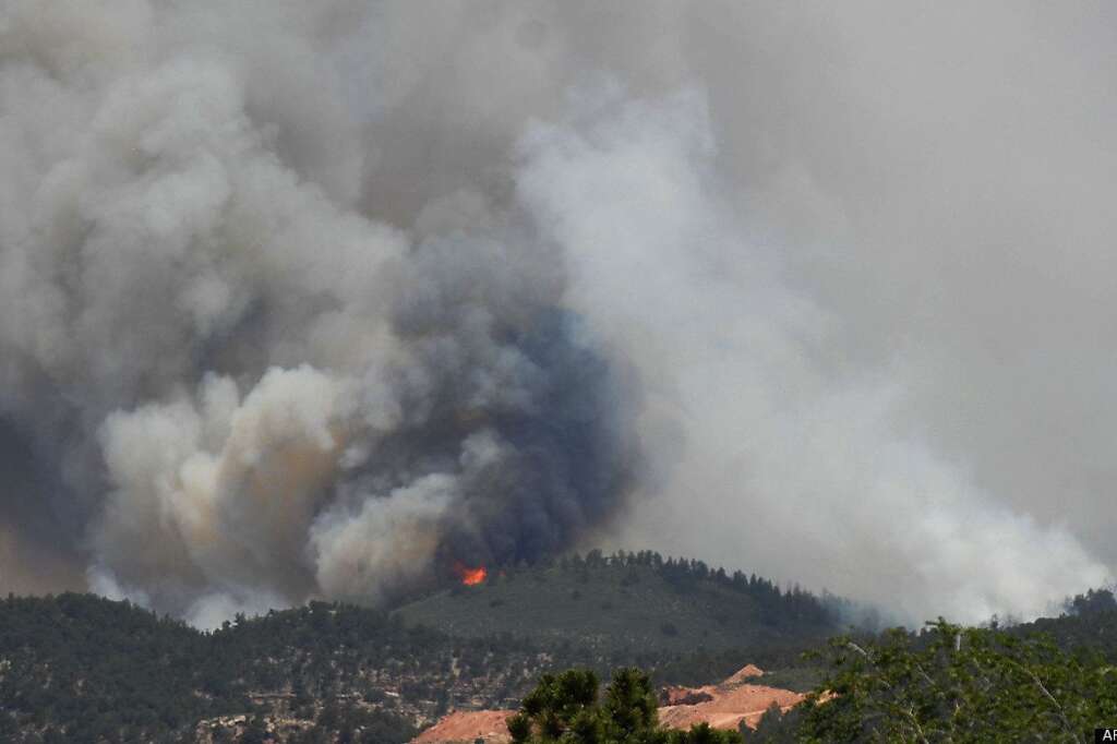 Smoke billows from a wildfire burning near Colorado Springs, Colo., on Sunday, June 24, 2012. The fire erupted and grew out of control to more than 3 square miles early Sunday, prompting the evacuation of more than 11,000 residents and an unknown number of tourists. On Saturday, a blaze destroyed 21 structures near the mountain community of Estes Park. (AP Photo/Bryan Oller)