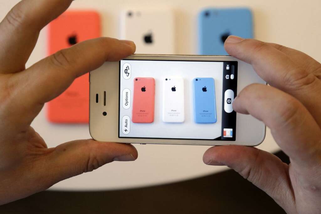 - Members of the media review the new iPhone 5c during a new product announcement at Apple headquarters on Tuesday, Sept. 10, 2013, in Cupertino, Calif. Apples latest iPhones will come in a bevy of colors and two distinct designs, one made of plastic and the other that aims to be the gold standard of smartphones and reads your fingerprint.(AP Photo/Marcio Jose Sanchez)