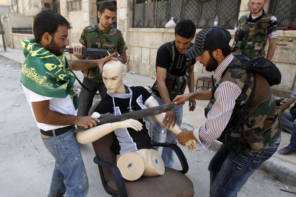 - Des rebelles habillent un mannequin pour qu'il ressemble à l'un d'entre eux durant les affrontements du quartier de Salaheddine, à Alep, le 17 août 2012.